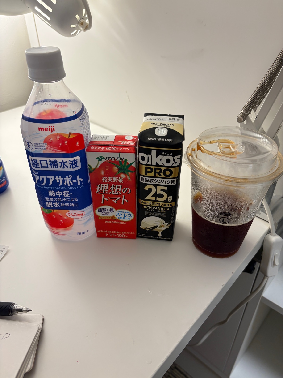 デスクに並べた水分、野菜ジュース、プロテイン。現場に出る日の小さな準備。